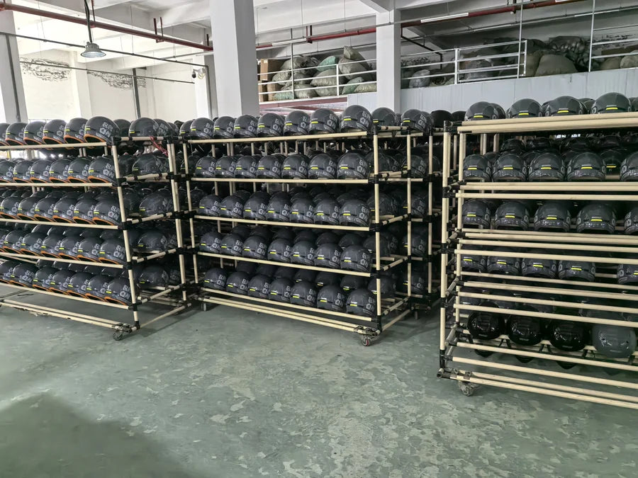 Helmet shells arranged on workshop racks at MASONTEX